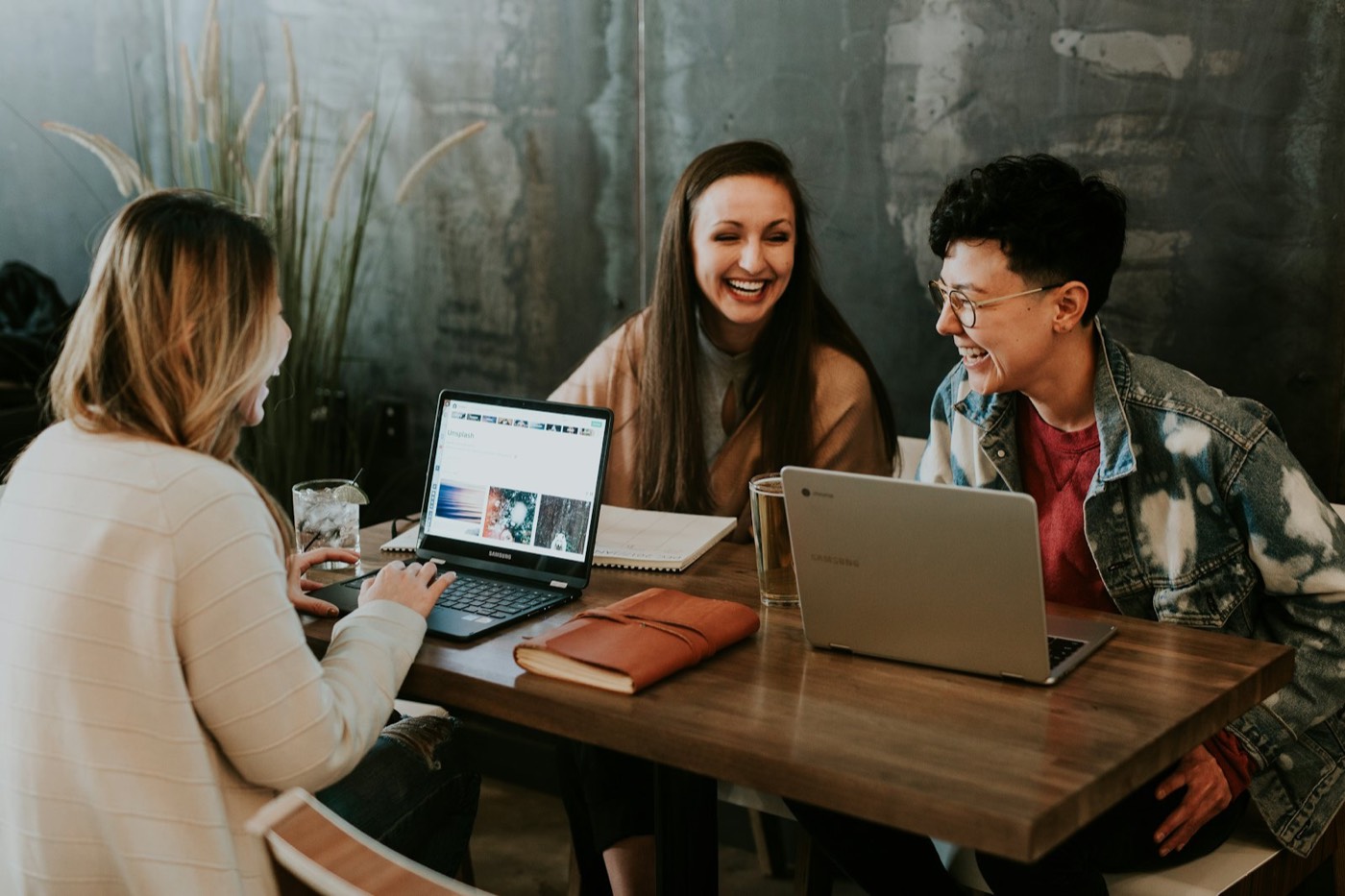 A small business team talking and laughing together around a table